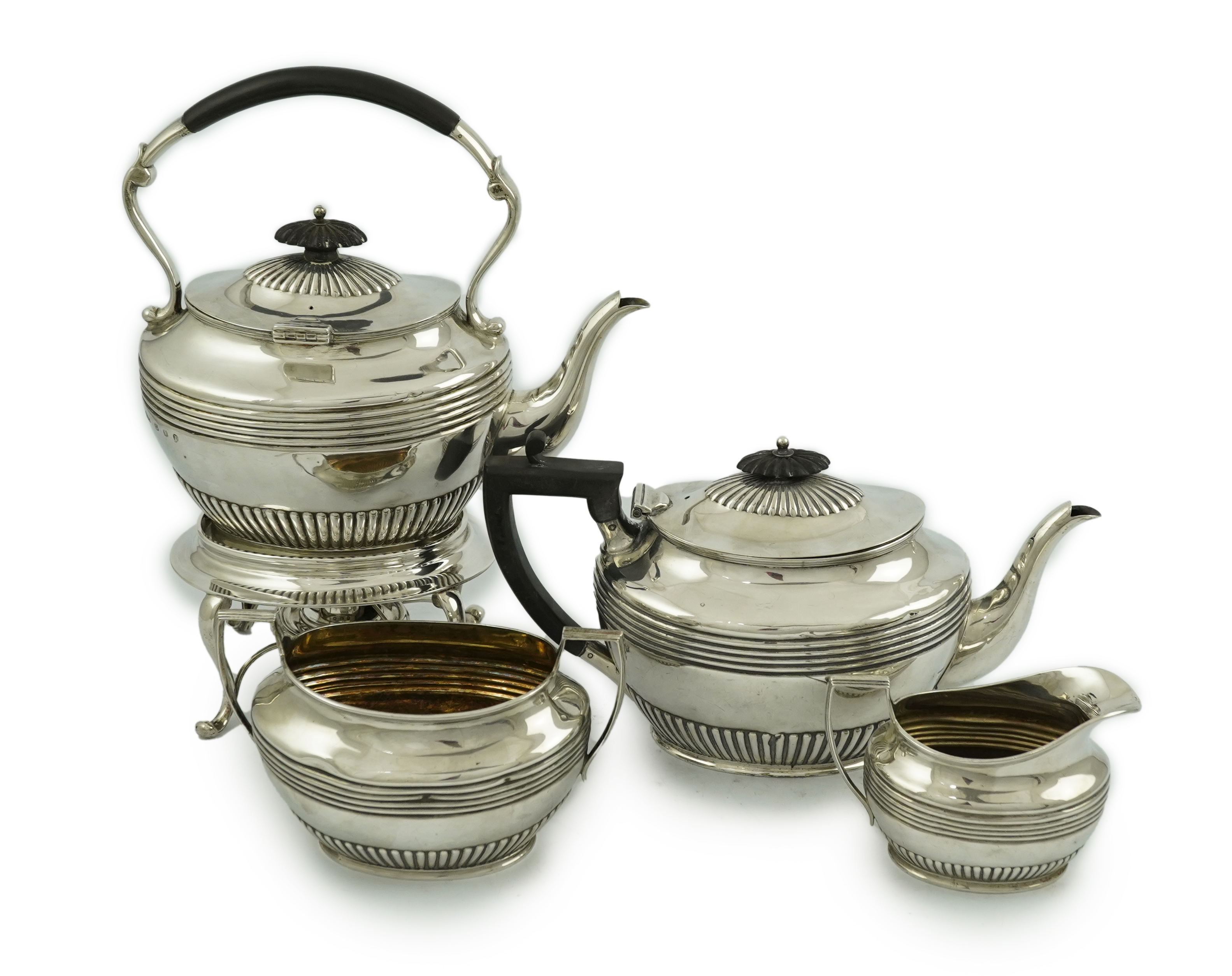 A matched Edwardian Scottish four piece demi fluted oval silver tea service by Wilson & Sharp